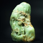A rare, large jade boulder carved with a longevity figure and attendants shown beneath a pavilion, with trees and clouds, century, 30.3 cm.